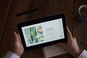 Close-up of hands holding a tablet showing a presentation slide, representing AI presentation makers in 2026