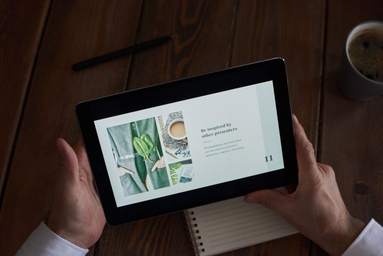 Close-up of hands holding a tablet showing a presentation slide, representing AI presentation makers in 2026