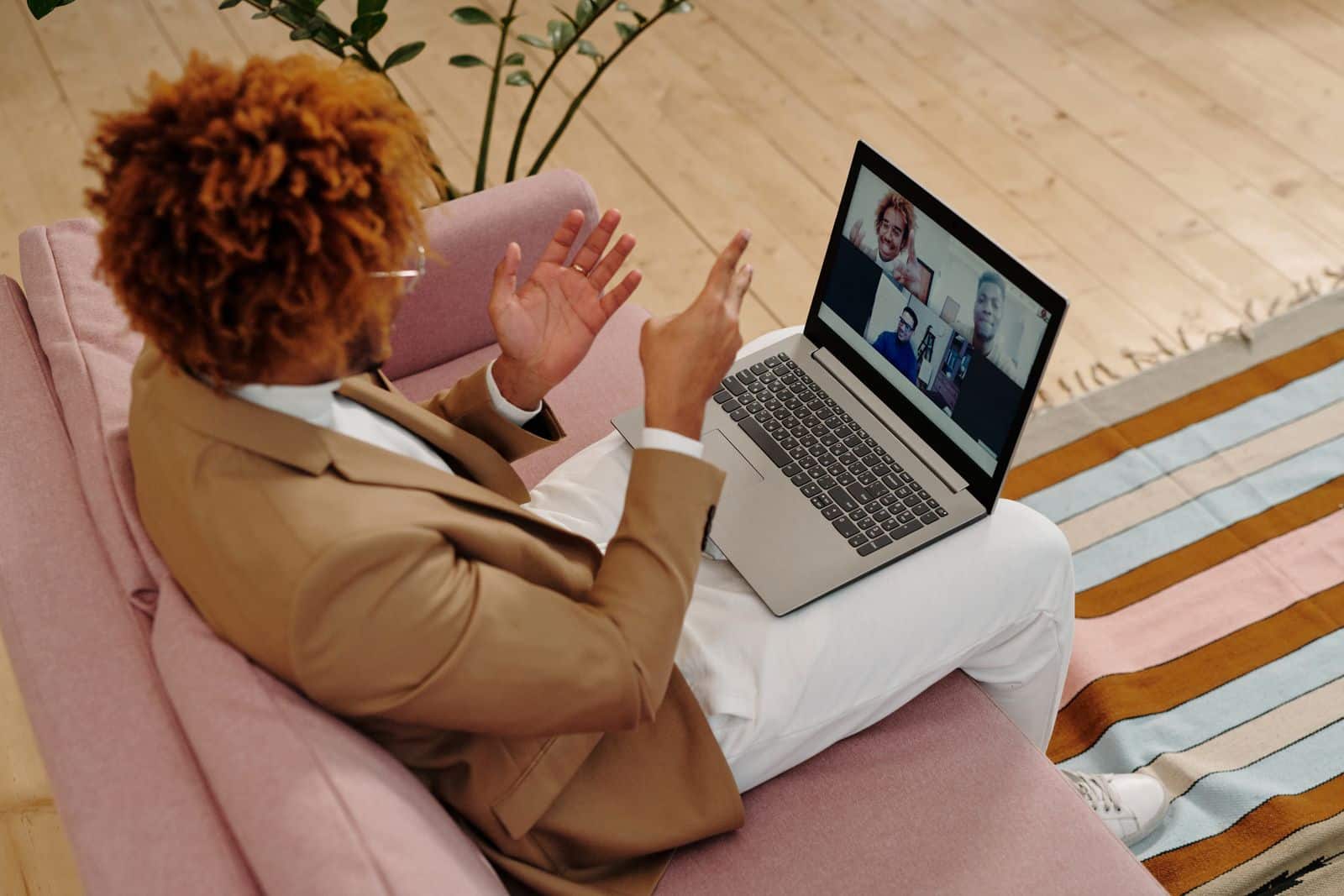 Adult man in a suit engaging in a video call while sitting on a sofa indoors, representing Grain AI meeting recorder