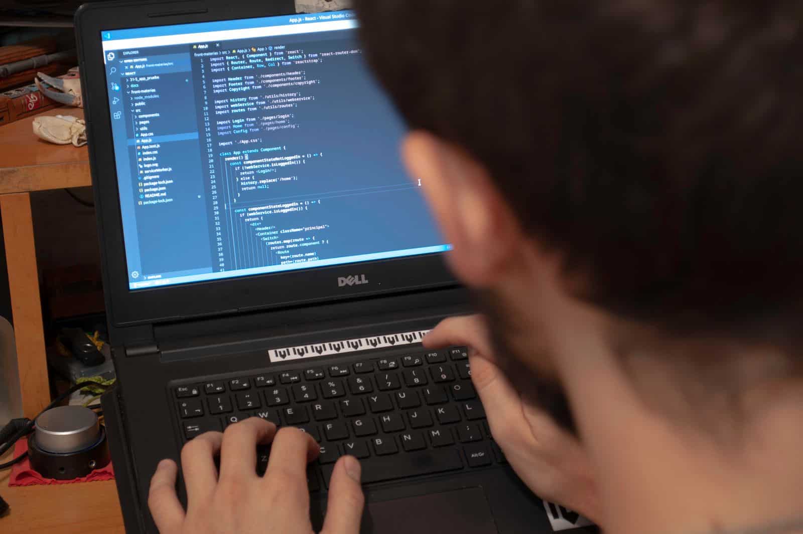 Programmer typing code on laptop, representing Hostinger AI Website Builder