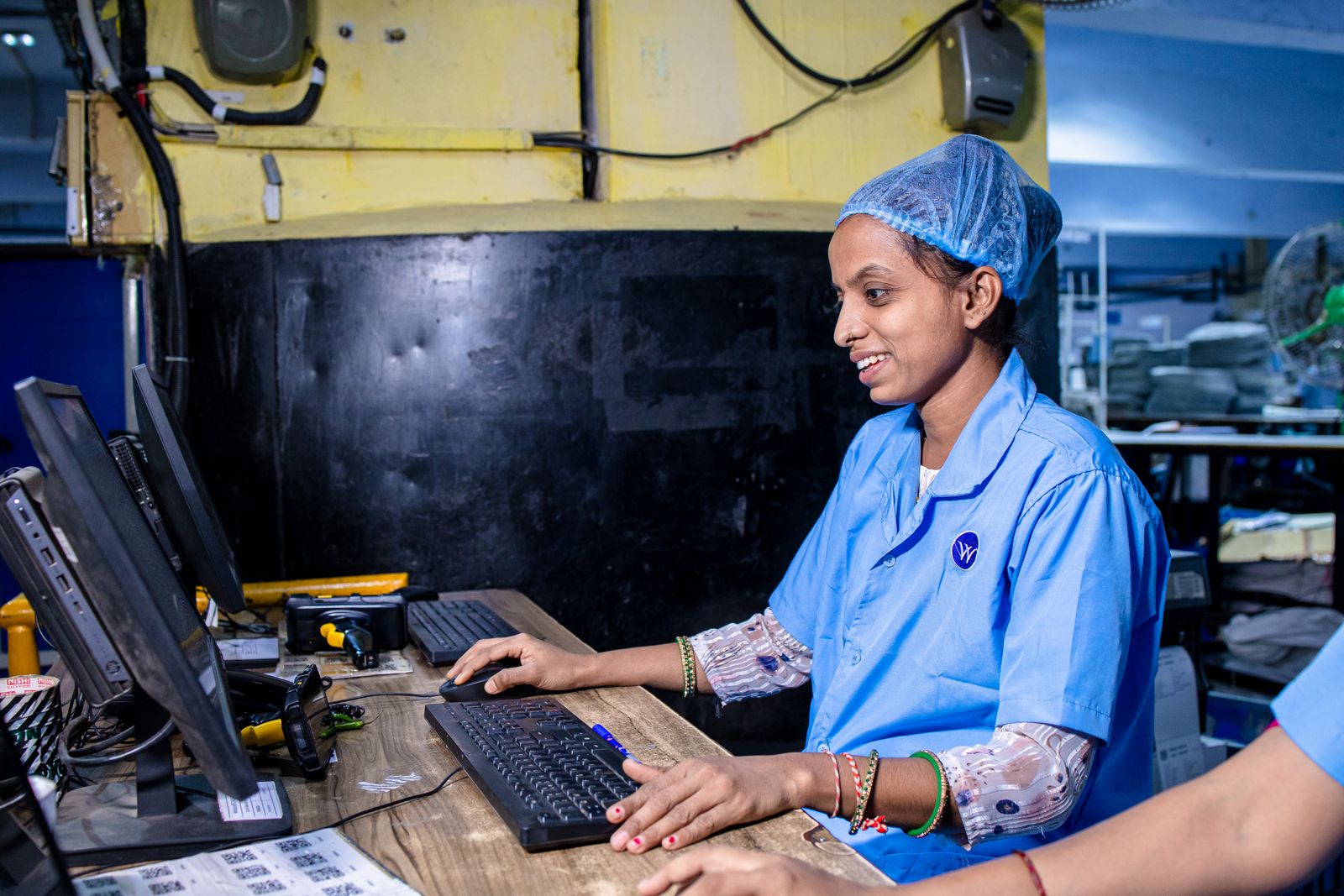 Smiling worker at a computer station, representing India's enterprise AI and on-device AI PC adoption