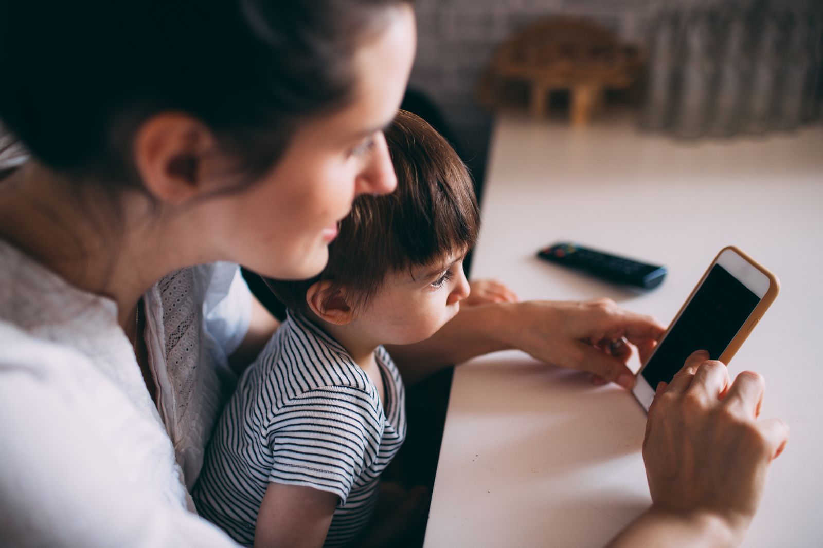 A mother and child looking at a smartphone together, representing the Meta AI child-profiling privacy story