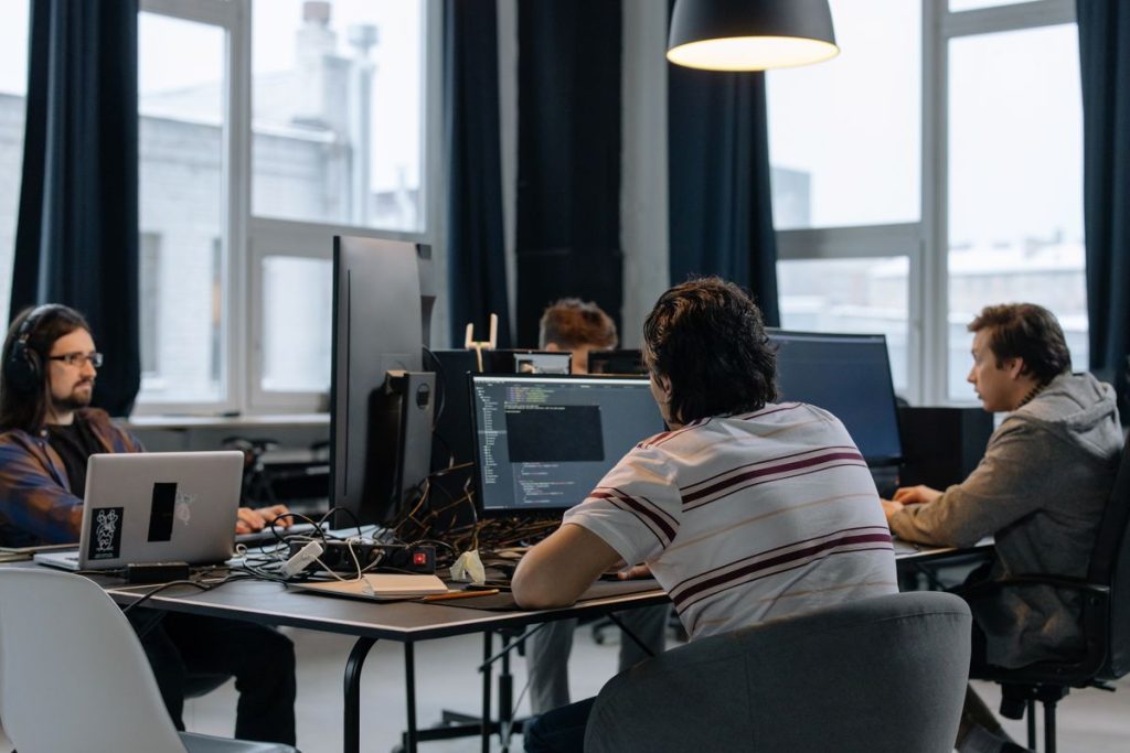 Team working at computers in a modern office, representing Microsoft Copilot's new Home, Code and Autopilot workspace