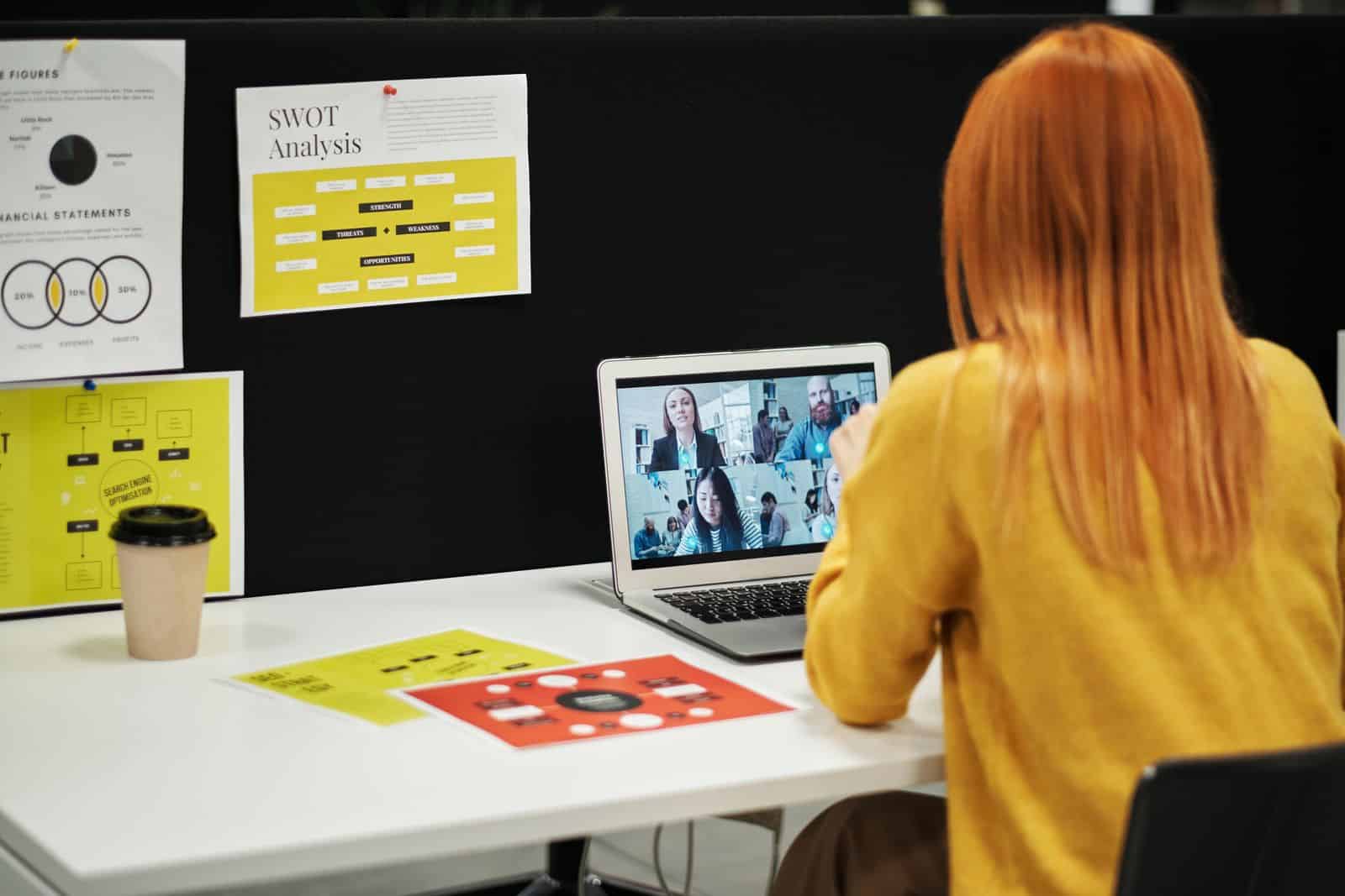 Adult using a laptop for a video call indoors, focusing on the screen, representing tl;dv AI meeting recorder